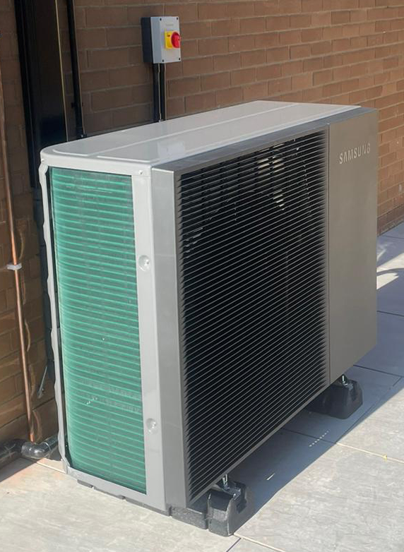 The fan unit of an air source heat pump in situ outside a UK home