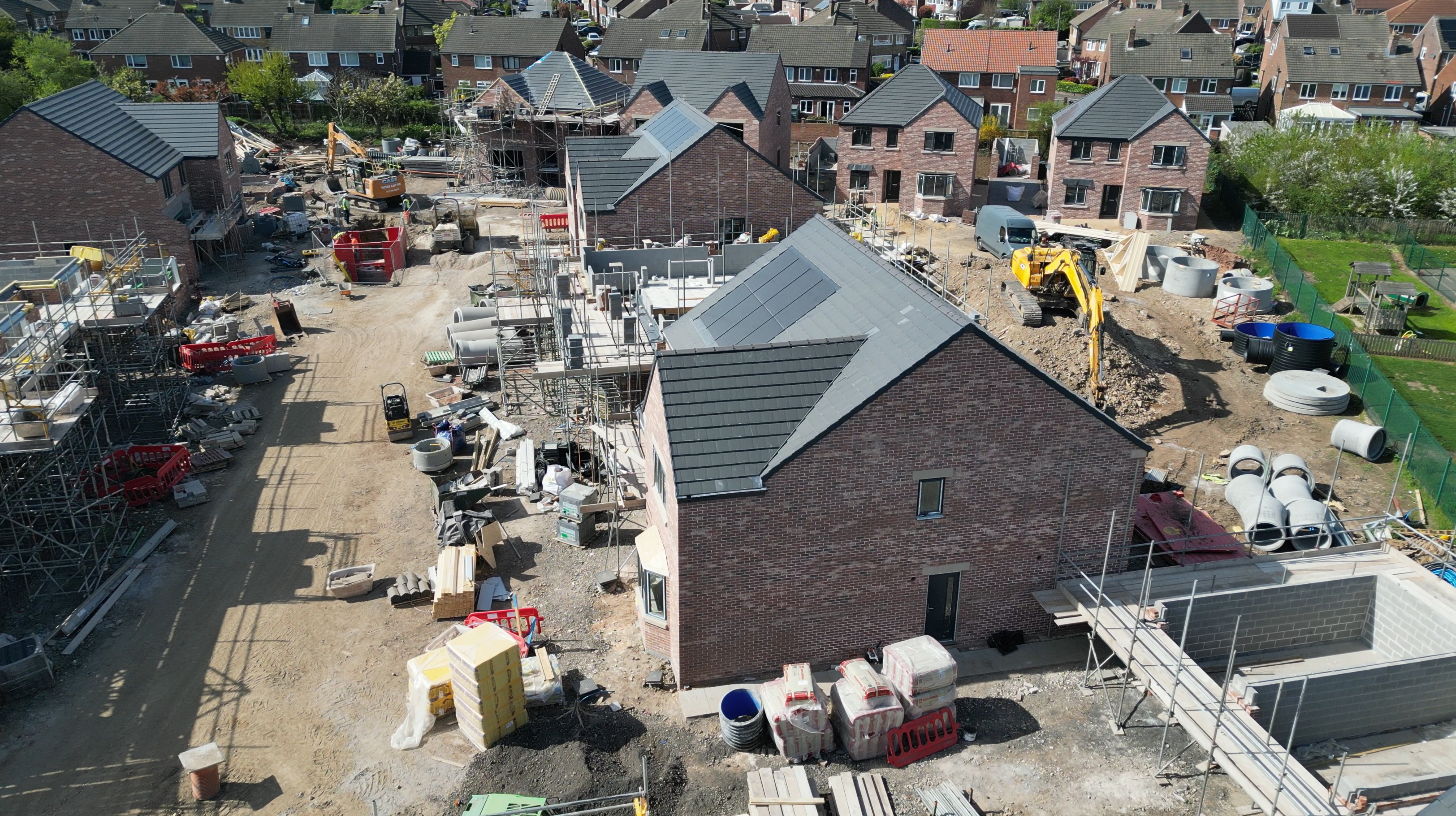 Ariel shot of a new build development with houses being built - solar panels on their roofs