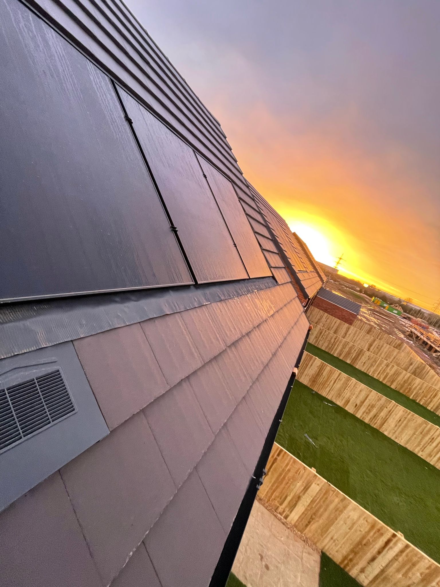 solar panels on roof with sun rising in background