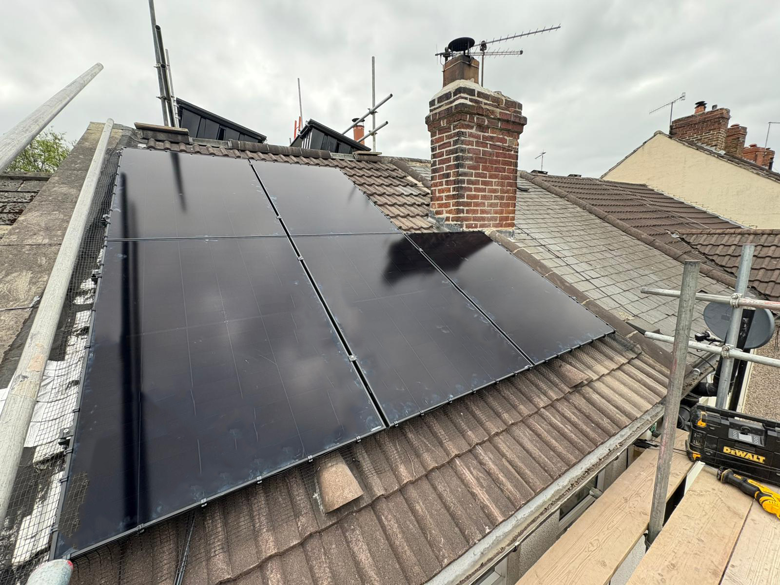 5 Black on Black solar panels on a pitched, tiled roof.
