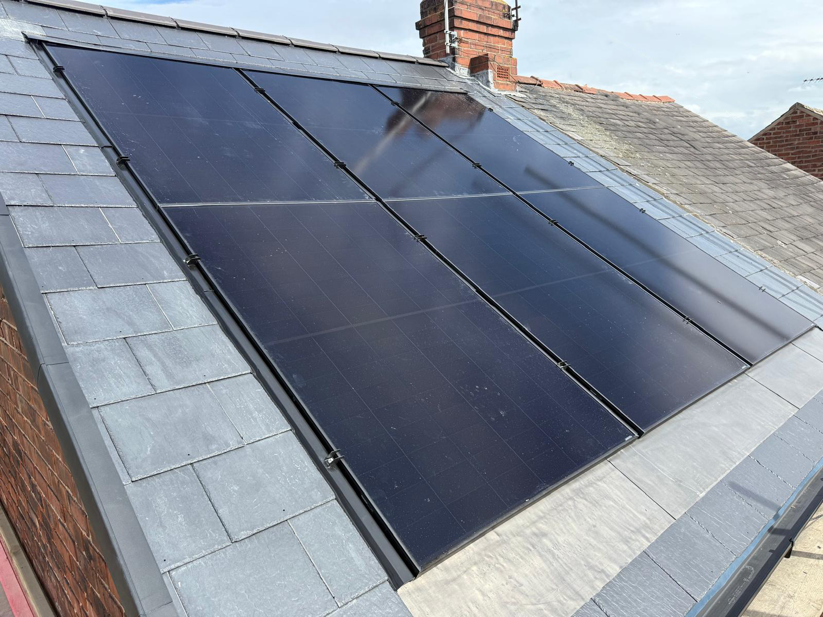 Black on Black solar panels mounted using an 'in-roof' system on a slate tiled roof. 