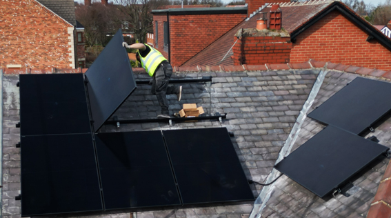 UKEnergi team working on installing solar panels on a roof.
